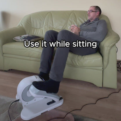 Person using under desk elliptical while sitting on a couch