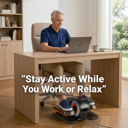 Active senior man working at a standing desk using a motorized under-desk elliptical, staying fit while working from home